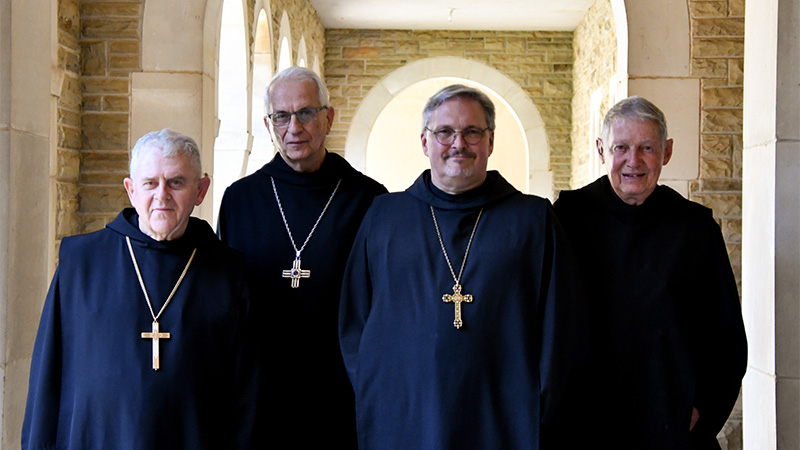 Outdoor photo of four priests